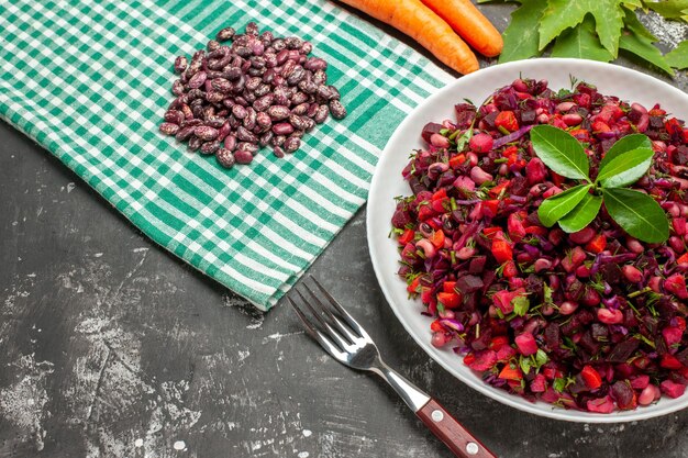 Ensalada de vinagreta de vista superior con remolacha y frijoles en superficie oscura