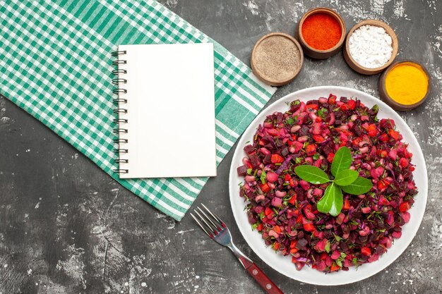 Ensalada de vinagreta de vista superior con remolacha y frijoles en superficie oscura