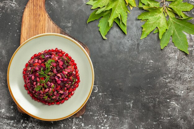 Ensalada de vinagreta de vista superior con remolacha y frijoles en la superficie oscura