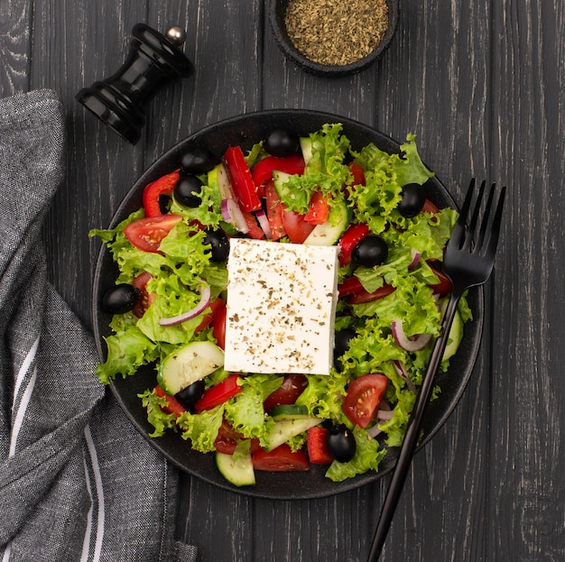 Foto gratuita ensalada de vista superior con queso feta, hierbas y tenedor