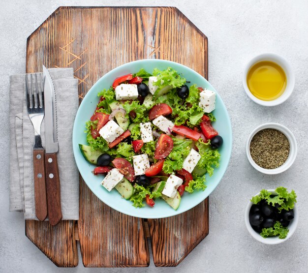 Ensalada de vista superior con queso feta en tabla de cortar con aceitunas