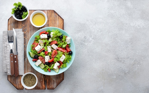 Ensalada de vista superior con queso feta en tabla de cortar con espacio de copia