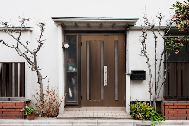 Entrada de la casa japonesa con árboles.