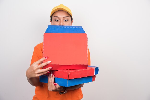 Entrega mujer sosteniendo cajas de pizza en el espacio en blanco