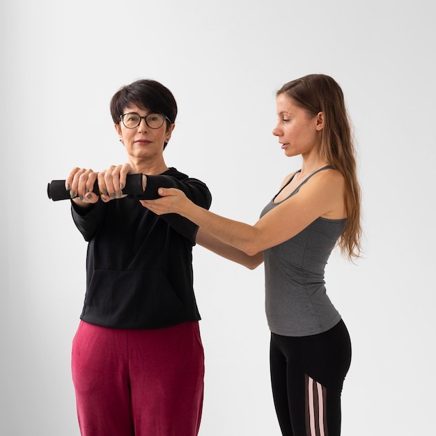 Foto gratuita entrenador ayudando a la mujer a recuperarse del covid