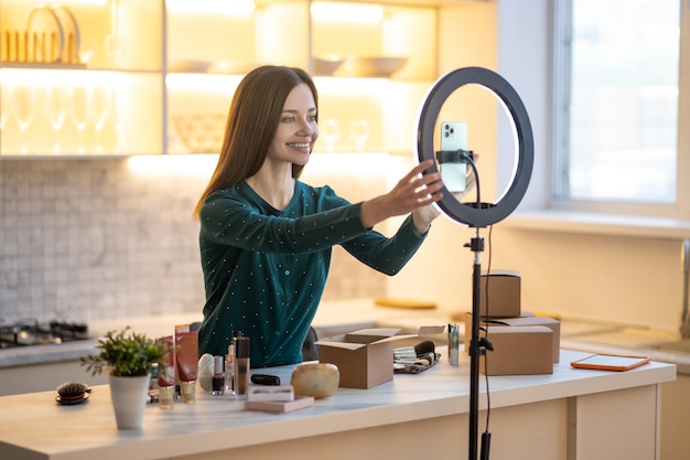 Entrenador de belleza joven sonriente preparándose para ir en vivo