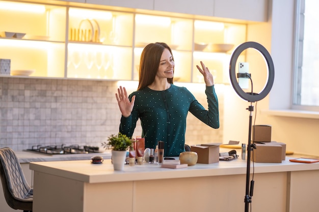 Entrenador de belleza joven sonriente preparándose para ir en vivo