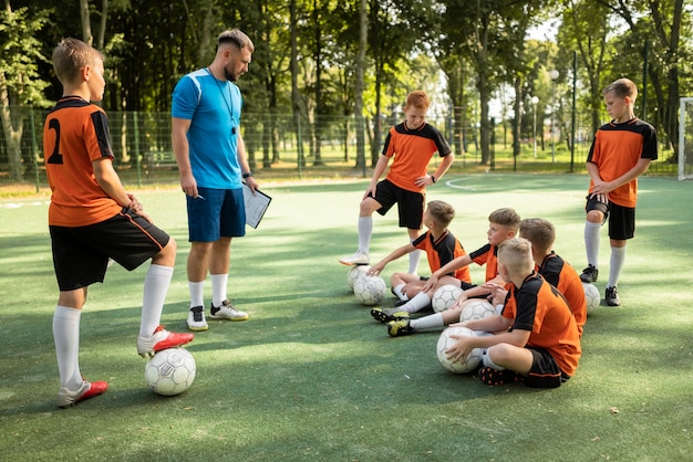 Foto gratuita entrenador de fútbol enseñando a sus alumnos