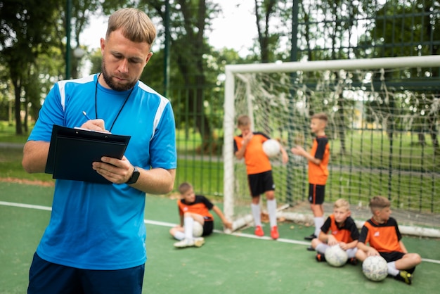 Entrenador de fútbol enseñando a sus alumnos