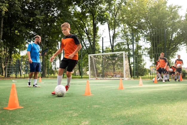 Foto gratuita entrenador de fútbol enseñando a sus alumnos