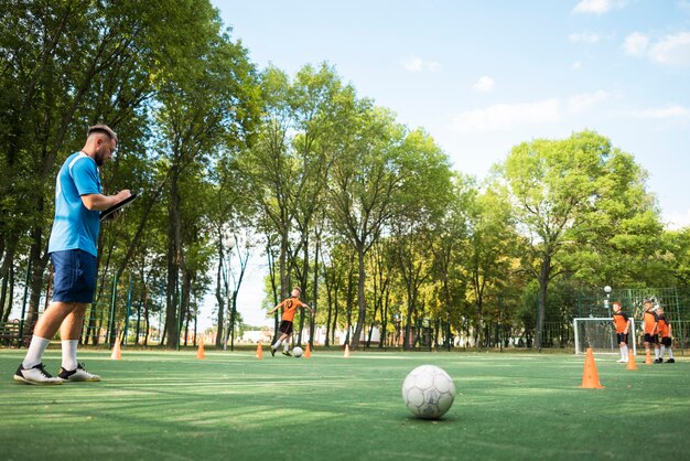 Entrenador de fútbol enseñando a sus alumnos