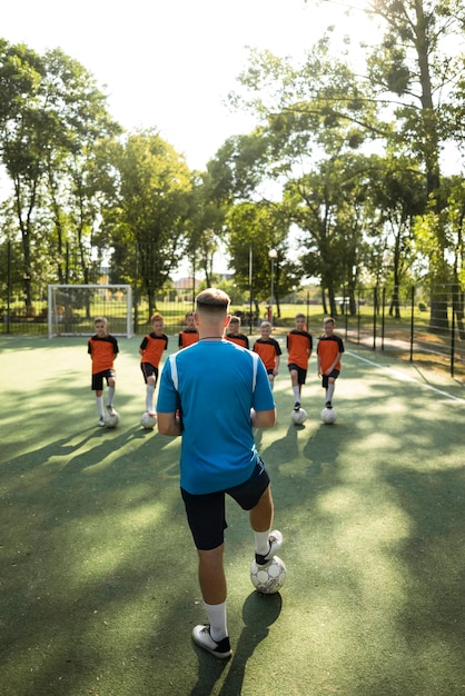 Foto gratuita entrenador de fútbol enseñando a sus alumnos