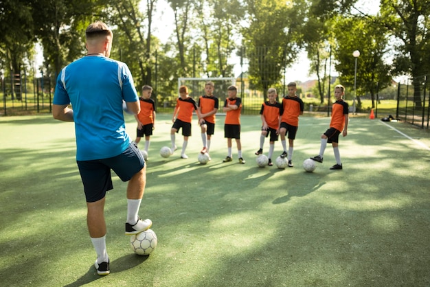 Entrenador de fútbol enseñando a sus alumnos