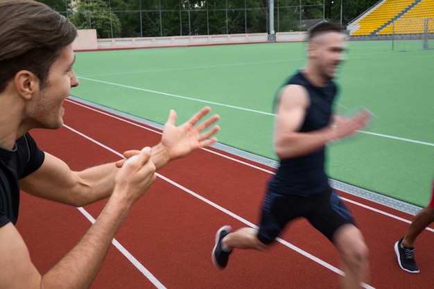 Entrenador gritando cerca de hombres jóvenes atletas multiétnicos