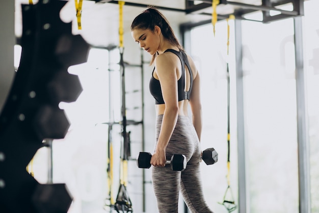 Foto gratuita entrenador joven haciendo ejercicio en el gimnasio