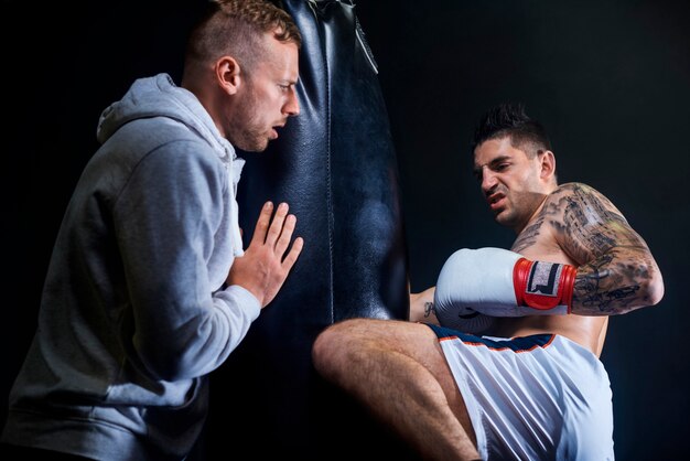 Entrenador masculino apoyando a boxeador musculoso