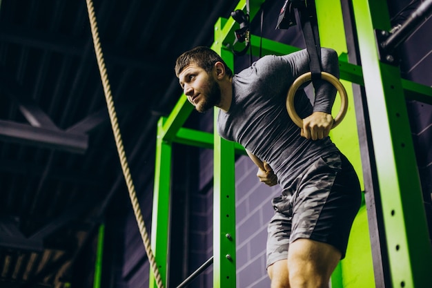 Foto gratuita entrenador masculino haciendo ejercicio en el gimnasio