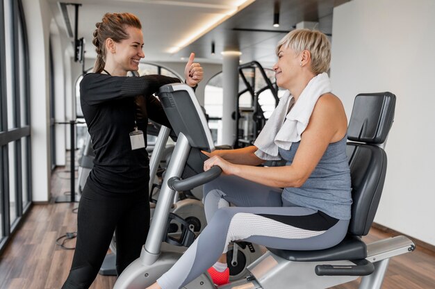 Foto gratuita entrenador del programa de entrenamiento y cliente en bicicleta