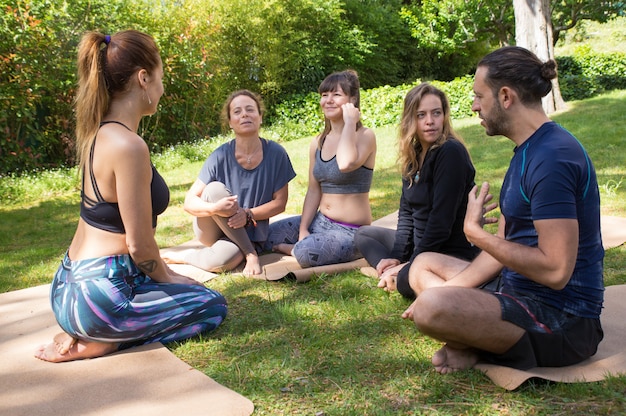 Foto gratuita entrenador de yoga instruyendo a los alumnos