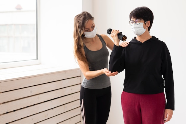 Entrenadora ayudando a mujer a recuperarse después del coronavirus