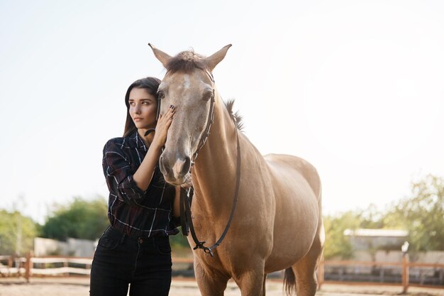 Entrenadora de caballos de carreras tomando un día libre de su trabajo para acariciar y cuidar de su propio semental