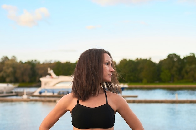 Foto gratuita entrenamiento al aire libre en la playa en la noche. retrato de mujer atlética de cerca, que hace ejercicios deportivos para una vida sana.