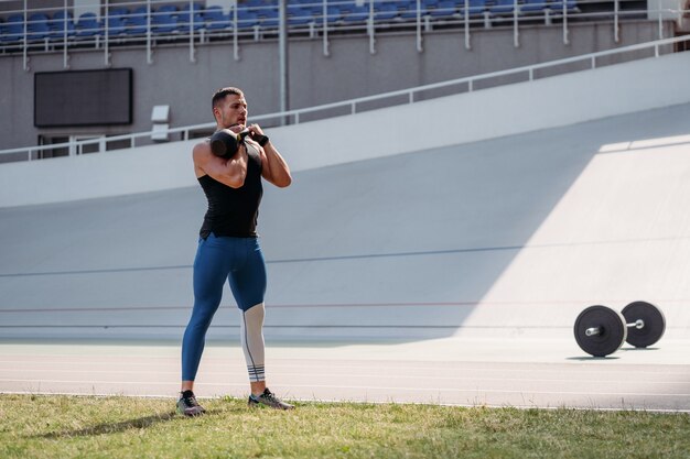 Entrenamiento de chico deportivo con pesas rusas.