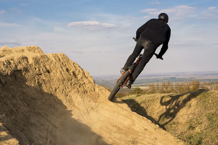 Foto gratuito entrenamiento de ciclista de montaña en una colina marrón