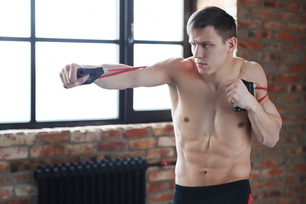 Entrenamiento de fitness hombre. Hombre sin camisa haciendo estiramientos en casa