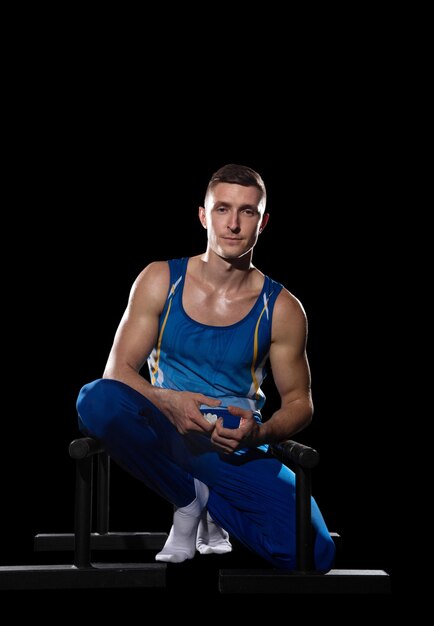 Entrenamiento de gimnasta masculino muscular en gimnasio flexible y activo caucásica ajuste chico azul ropa deportiva