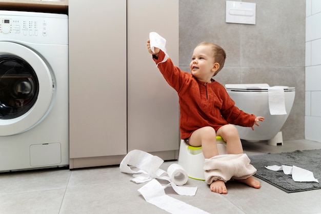 Foto gratuita entrenamiento para ir al baño de niño lindo de tiro completo