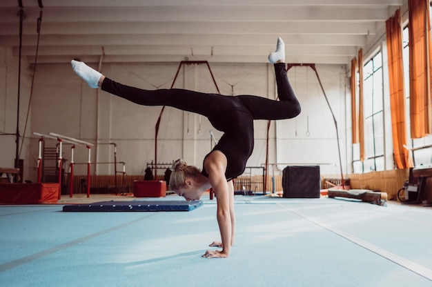 Entrenamiento de mujer lateral para el campeonato de gimnasia