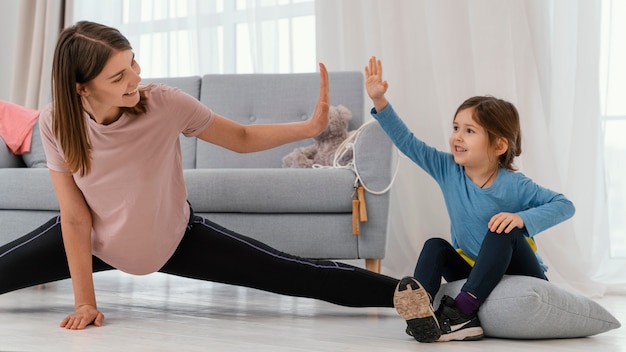 Entrenamiento de niña y madre de tiro medio