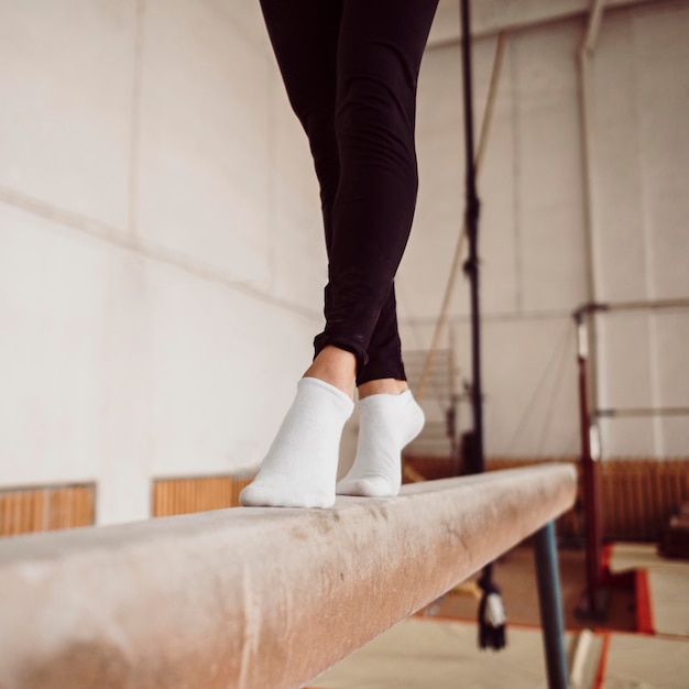 Foto gratuita entrenamiento de piernas de mujer atlética en barra de equilibrio