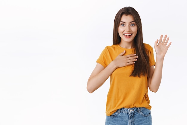 Entusiasta linda chica promete que dice la verdad, presione una mano contra el corazón, levante la palma y jure, haga juramento o juramento, sea sincero, espero que crea, sonriendo despreocupado, fondo blanco