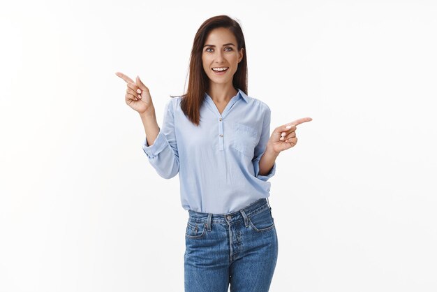 Entusiasta mujer adulta despreocupada bailando afortunada optimista sintiéndose feliz relajada alegremente apuntando hacia los lados dos opciones introducen espacio de copia sonriendo indican fondo blanco izquierdo y derecho