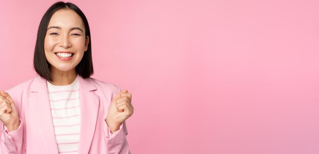 Entusiasta vendedora mujer corporativa asiática dice sí lograr el objetivo y celebra triunfante lookin