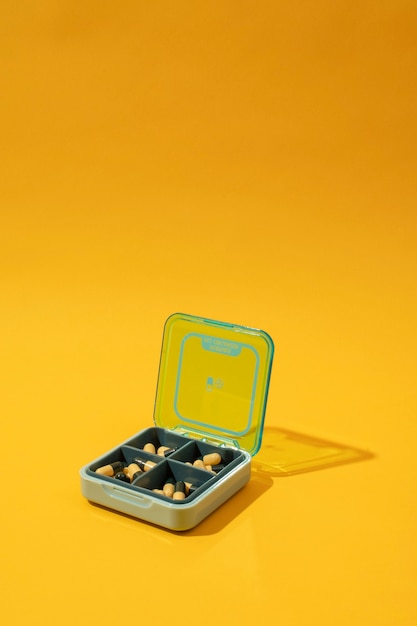 Foto gratuita envase de pastillas con ángulo alto de fondo amarillo