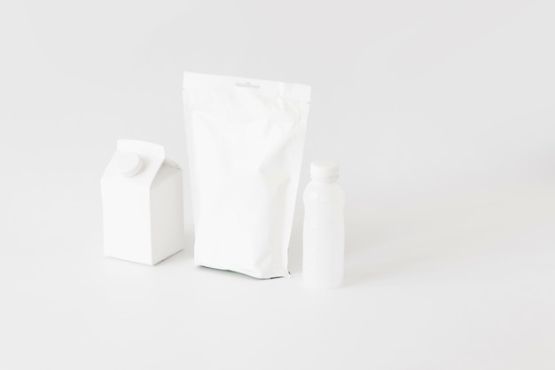 Envases de cartón blanco y botellas para productos lácteos.