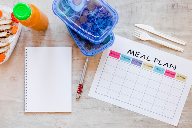 Envases de comida planos con cuaderno