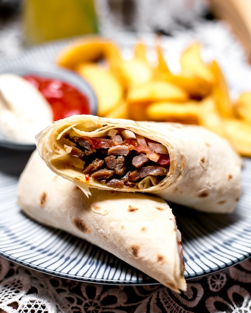 Envoltura de cordero servida con papas fritas, ketchup y mayonesa