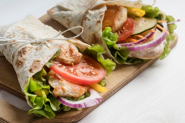 Envoltura de kebab con carne y verduras sobre tabla de madera