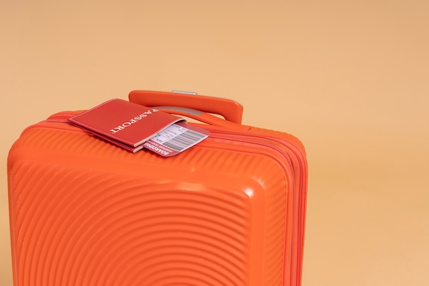 Foto gratuita equipaje naranja para viajar con pasaporte y boleto de avión.