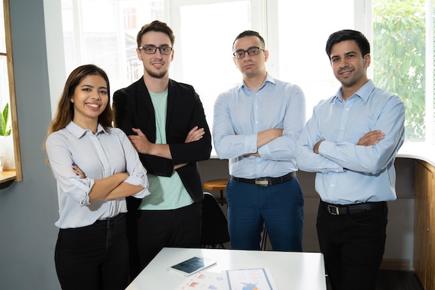 Foto gratuita equipo acertado positivo del negocio que presenta en el lugar de trabajo