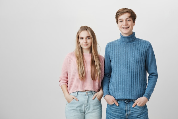 Equipo amigable, colaboración y cooperación. Feliz pareja sonriente, vistiendo ropa de punto y jeans