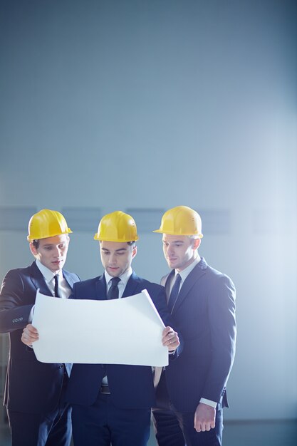 Equipo de arquitectos trabajando en planos de construcción