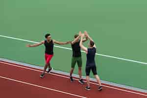 Foto gratuita equipo de atleta multiétnico de pie en la pista de atletismo