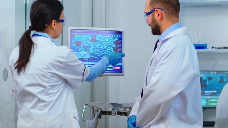 Foto gratuito equipo científico discutiendo frente a computadora mirando el desarrollo de virus en un laboratorio equipado moderno. material multiétnico que analiza la evolución de la vacuna utilizando alta tecnología para investigar el tratamiento.
