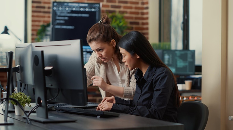 Foto gratuito equipo de compañeros de trabajo que comparan los códigos fuente que se ejecutan en la pantalla del portátil y en el monitor de la computadora en la oficina de desarrollo. desarrolladores de software que colaboran en el proyecto del grupo de codificación de datos mientras están sentados en el escritorio.