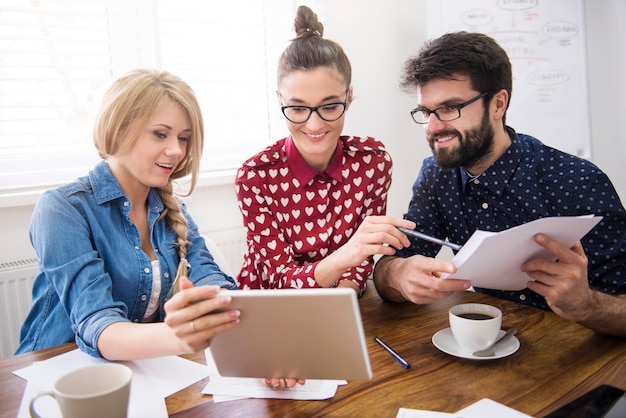 Equipo de compañeros de trabajo trabajando con una tableta digital